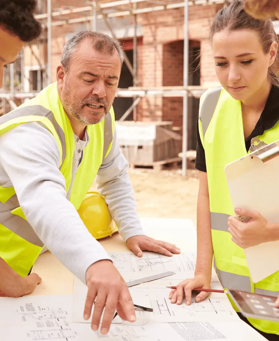 Group of builders looking at plans on construction site