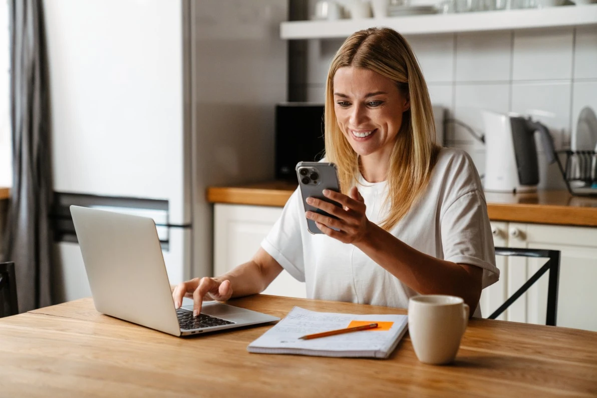 Happy woman using laptop to contact Priority One Building Group