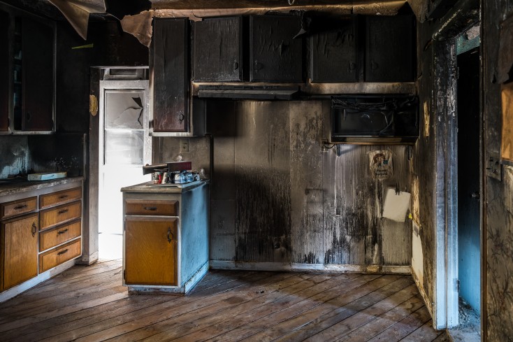 Kitchen after fire has happened. Covered in soot